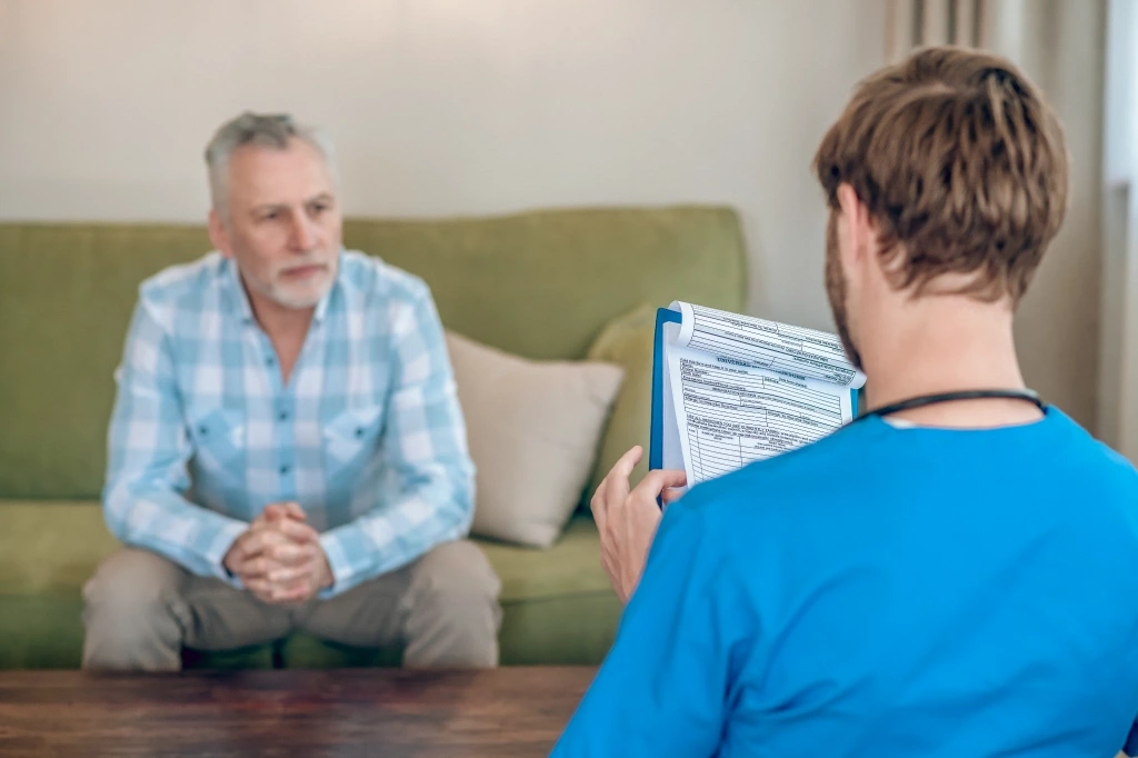GP conducting a medical assessment during an after hours home doctor visit in Australia