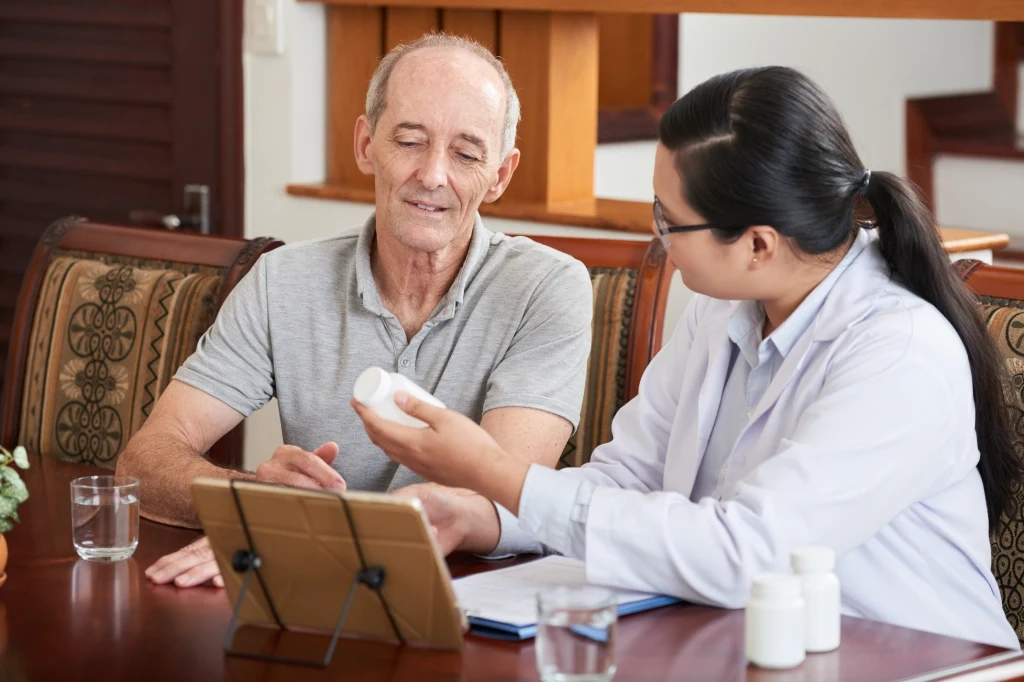 Home doctor issuing a prescription during an after hours GP home visit in Australia following clinical assessment